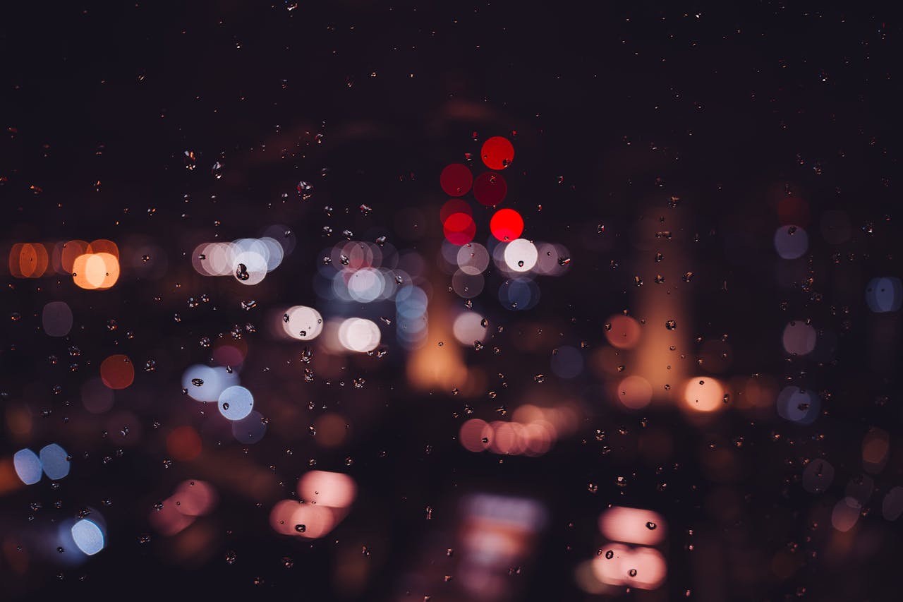 Bokeh city lights and raindrops on glass create a magical nighttime ambiance in London.